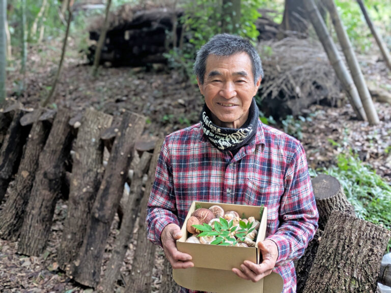 自然栽培しいたけを持つ高塚さん